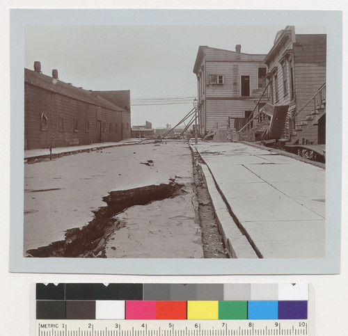 Dore St. [Subsidence of street and sidewalk. Note buttressed houses in distance.]