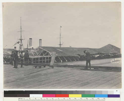 [View of damage along wharf. Man of War "New York" at pier. No. 15.]