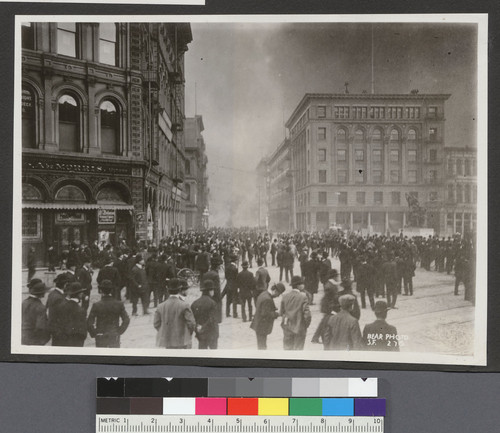 [Street scene of crowd watching fire on Battery St. From Market St. Donahue Labor monument, right.]