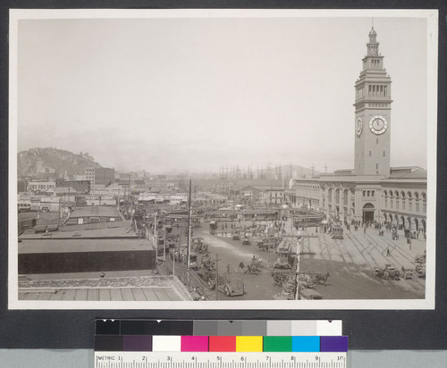 One year after. Busy East Street showing 12 cars on and about the new car loop at the ferries. Every building on the left is new