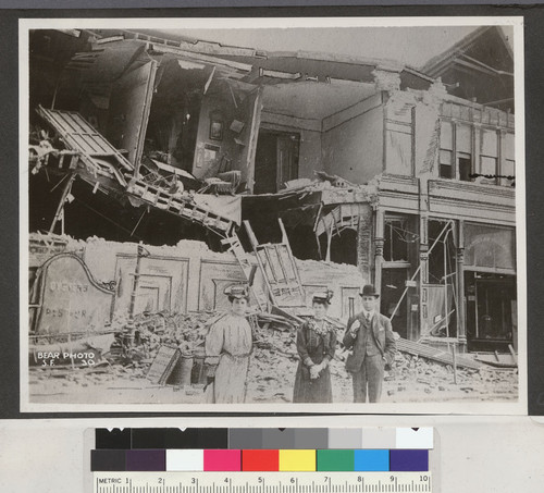 [Man and women posing before ruins near City Hall.]