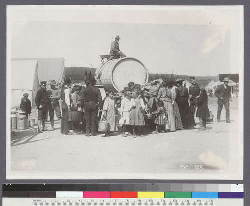 [Refugees gathered at water wagon. Unidentified refugee camp.]