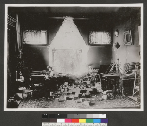 [Residential interior with hole in wall from collapsed fireplace and chimney. Unidentified location.]