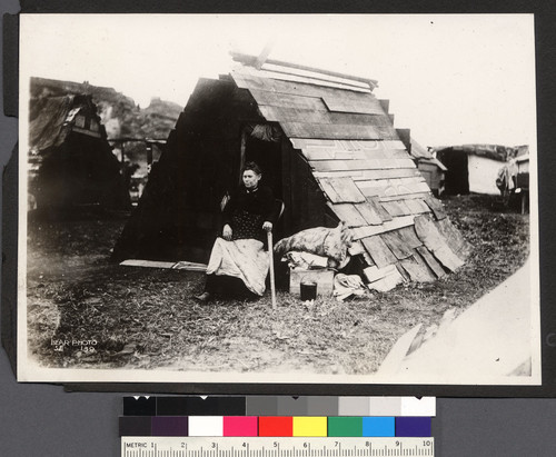 [Woman refugee in makeshift shelter.]