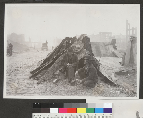 [Men at makeshift refugee shelter.]