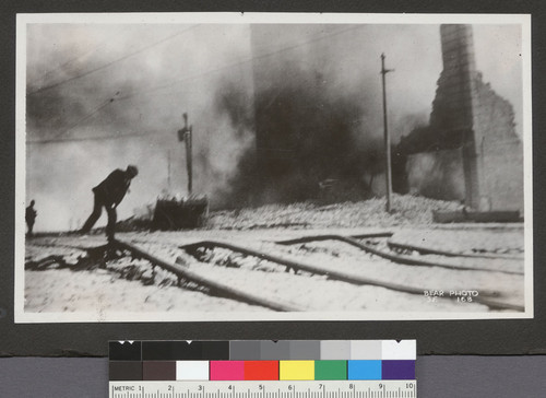 [Street scene during fire. Streetcar rails buckled from earthquake.]