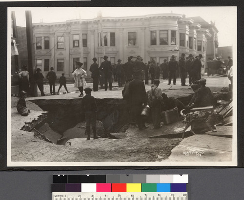 [Sink hole on Eighteenth St. at Valencia. Structure in background has sunk one story into former Lake McCoppin.]