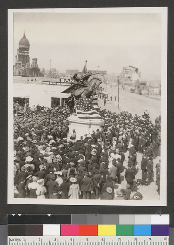 [Crowd gathered at unidentified event. At Van Ness Ave. and Market St. City Hall in distance.]