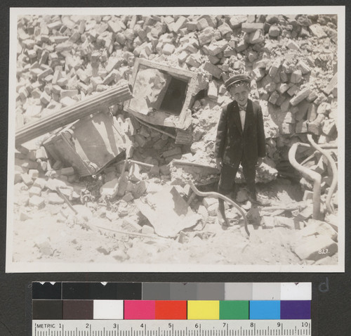 [Boy posing among rubble. Unidentified location.]