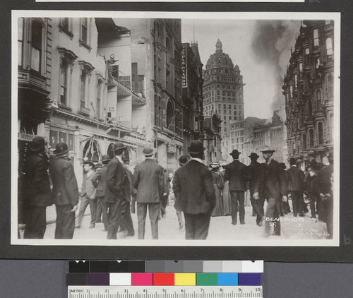 [Crowd gathered on O'Farrell St. watching fire on Market St. Call Building, center.]