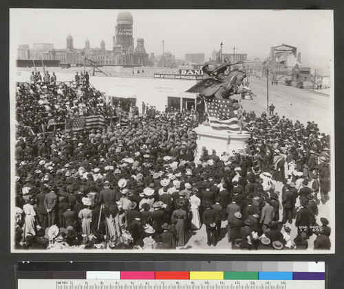 [Crowd, including soldiers, gathered for unidentified event. At Market St. and Van Ness Ave. City Hall in background.]