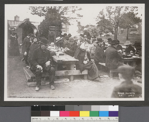 [Refugees eating at camp tables.]
