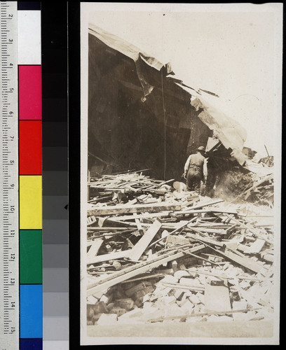 [Man walking in rubble, unidentified location.]