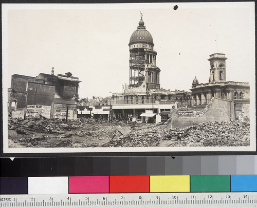 [Rubble along Market St. City Hall in background.]