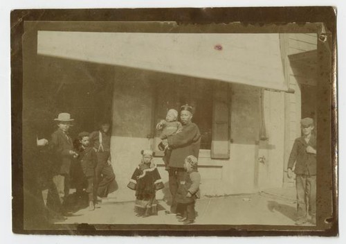 Man and Children Standing in front of Ah Louis Store