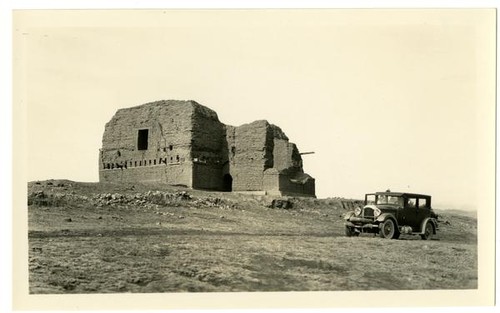 [Car parked in front of stone house]