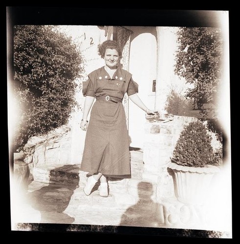 [Unidentified woman standing on front steps]