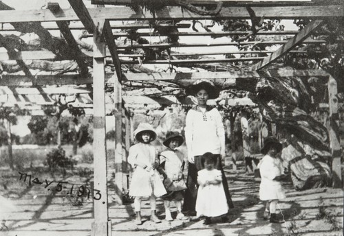 Elizabeth Ezaki Brown, William Ezaki, Ruth Ezaki and James Ezaki with the mother under the Carpinteria grapevine, the largest grapevine in the world. Carpinteria : 1913