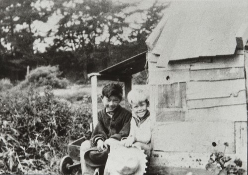 Kenji Ota and Bobby Bates sitting in front of play house, Carpinteria : 1926