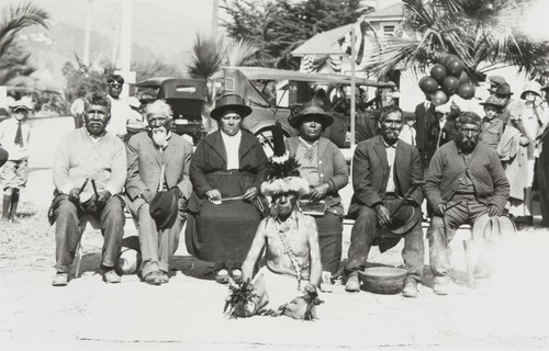 Central California Indians, Ventura County Fair : 1923. Bob Bautista (Tachi Yokuts) in dancing regalia, seated in foreground. Left to right on bench: Jim Wilcox (Yokuts), José Peregrino (Winai) Romero (Ventureño Chumash), Juliana Ygnacio (Barbareño Chumash), Lucrecia García (Barbareño Chumash), Juan Solano (Migueleño Salinan), José Juan Olivas (Ventureño Chumash)
