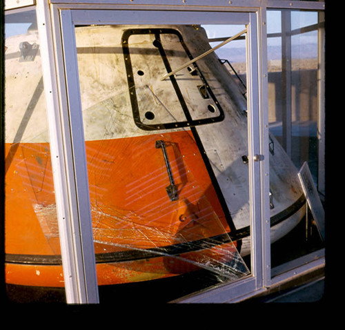 View of damage to the display case for the Apollo scale model space capsule at Apollo Park