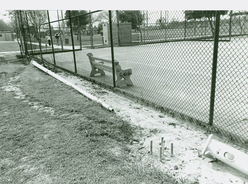 View of park bench inside the tennis enclosure at Roosevelt Park