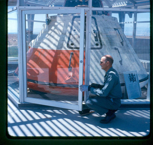 View of a staff fixing the damaged display case of the Apollo scale model space capsule at Apollo Park