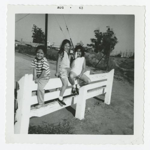 Girls sitting on a fence, Los Nietos, California