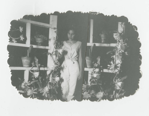 Mary Jimenez Stout stands in between a lattice wall, Los Nietos, California