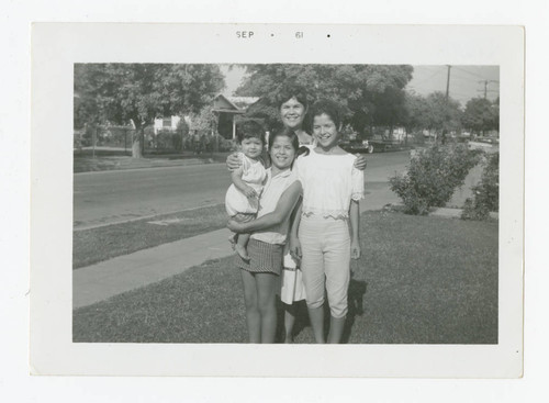 Mary Barajas with her three daughters in the front yard of a residence, Los Nietos, California