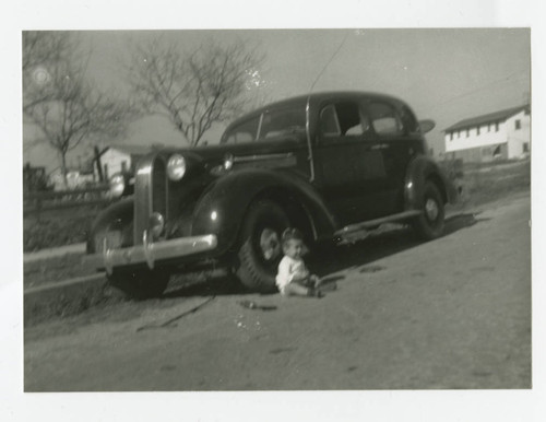 Angel Cabral sitting in front of family car, South Whittier, California