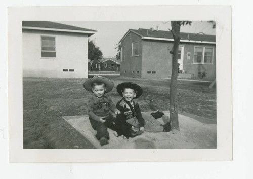 Boys sitting in the backyard, Los Nietos, California