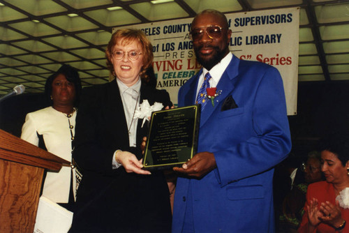 County Librarian and Isaac Hayes Hold Plaque