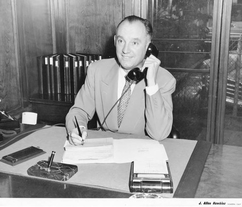 Man Sitting at his Desk and Talking on the Phone