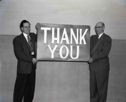 Unidentified men with a Thank you sign