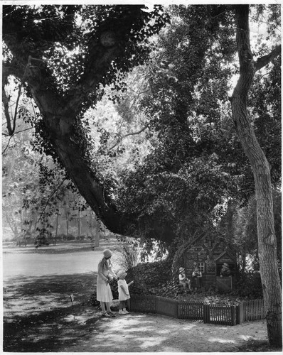 Woman and child viewing the Hansel and Gretel Cottage at Busch Gardens