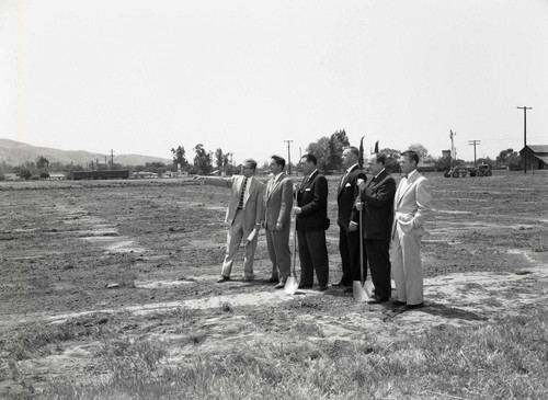 Men pose at a groundbreaking