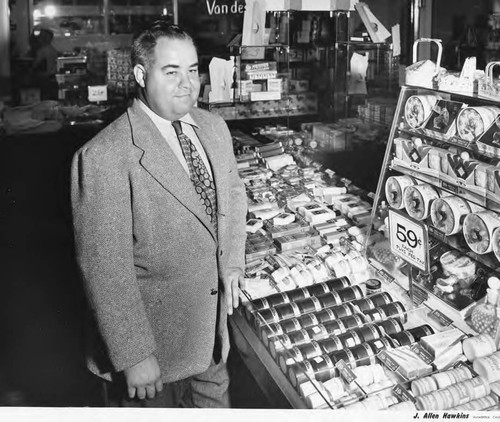 Man Standing Next to Display of Sofskin Cream