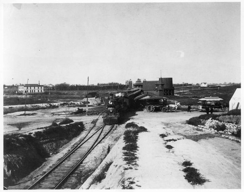 Original Raymond Station in front of water tank, present sta. under construction behind train. Pasa. Canning Co. N/E Cor. Raymond & Glenarm, extreme left of picture