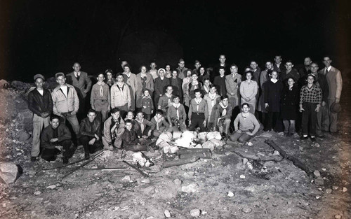 Boy Scout Troop with men and women behind a campfire