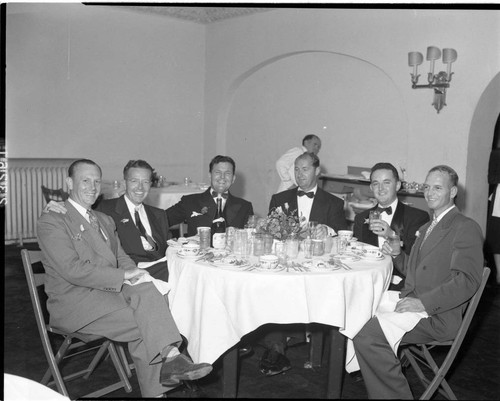 Six men seated a dinner table at banquet