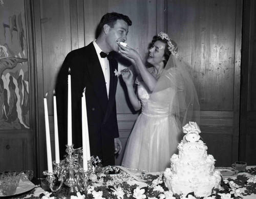 The bride feeding the groom wedding cake