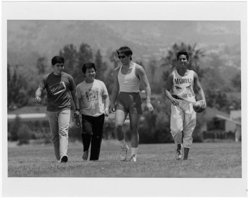 Students with a Football Cross the Athletic Field on Woodbury University's Burbank Campus