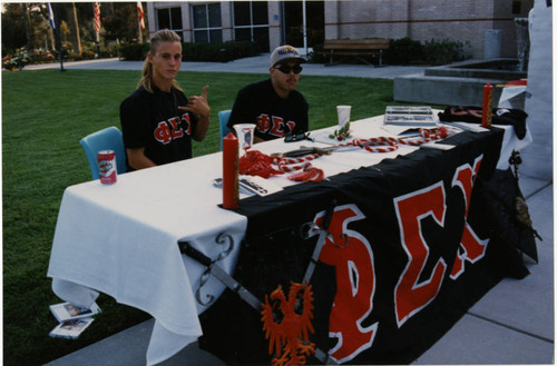 Two members of Phi Sigma Chi at a Booth during Woodbury University's 1995 Orientation