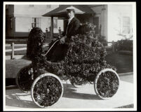 Robert Gaylord seated in a decorated automobile in the Tournament of Roses Parade, Pasadena, 1901