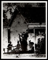 Two men seated at a table beside the Owens family house, Los Angeles, 1884