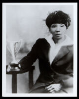 Relative of Bessie Coleman seated beside a trophy cup, 1920s