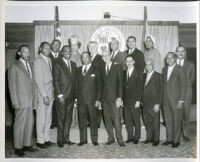 Tom Bradley and others gathered in front of the City of Los Angeles Seal, Los Angeles, 1960s