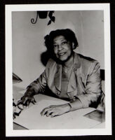 Bessie Bruington Burke seated at a desk, 1955-1968