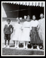 African American family in front of a house with an awning, 1910-1920